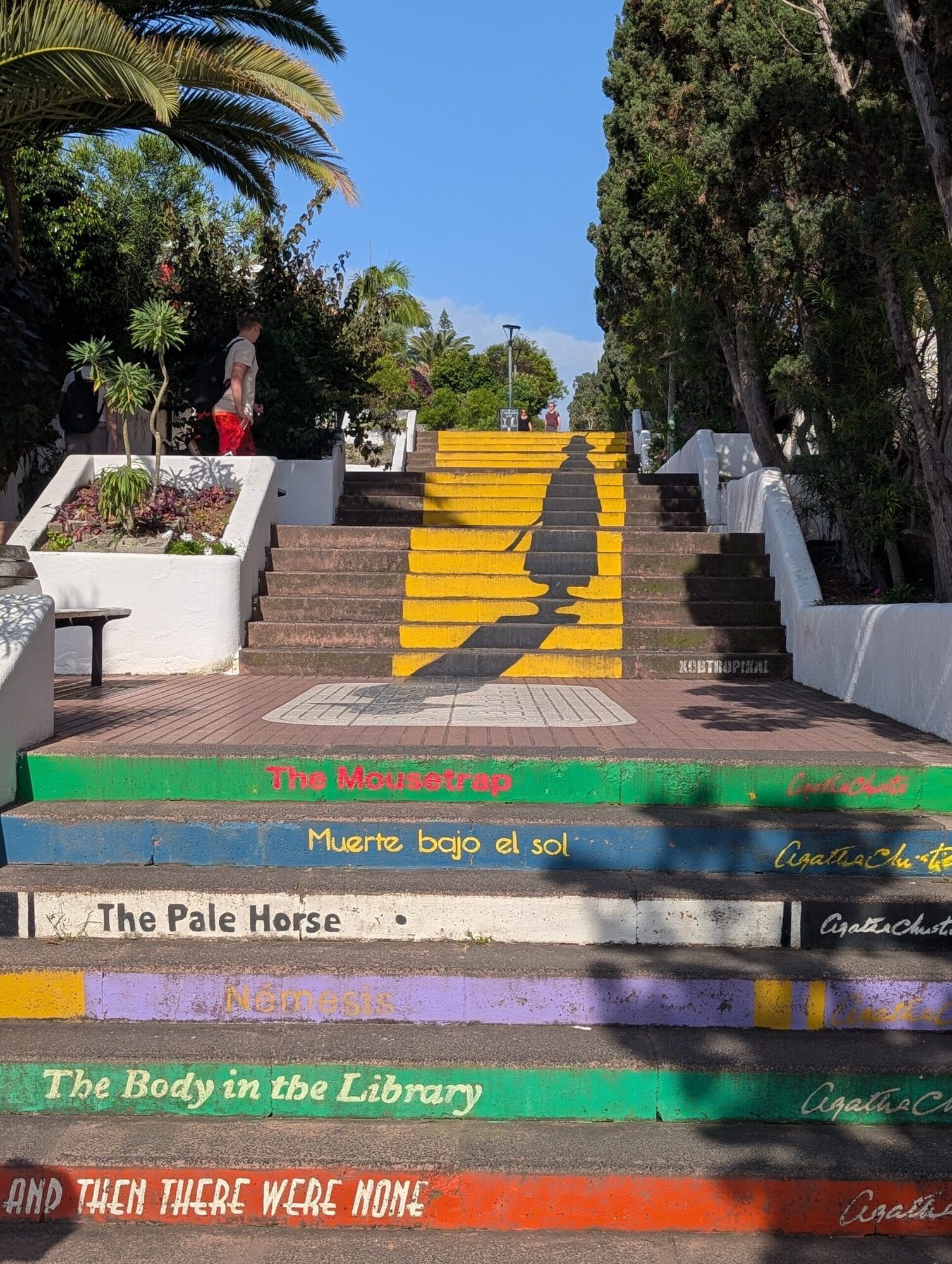 Outdoor stairs in Puerto de la Cruz painted in bright colours, with a book title on each step