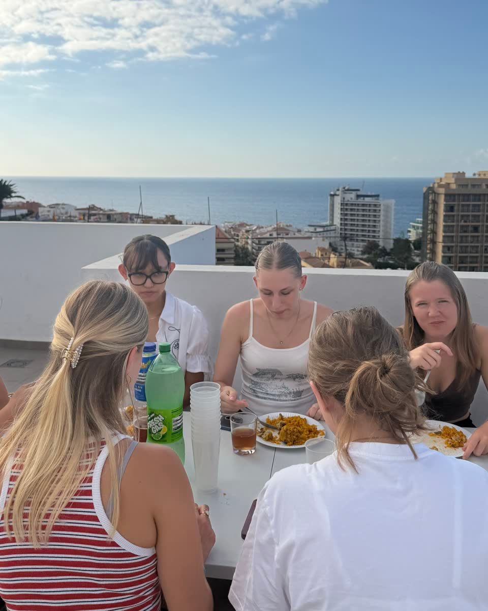 Guests sharing paella on the rooftop at Canary Campus Hostel