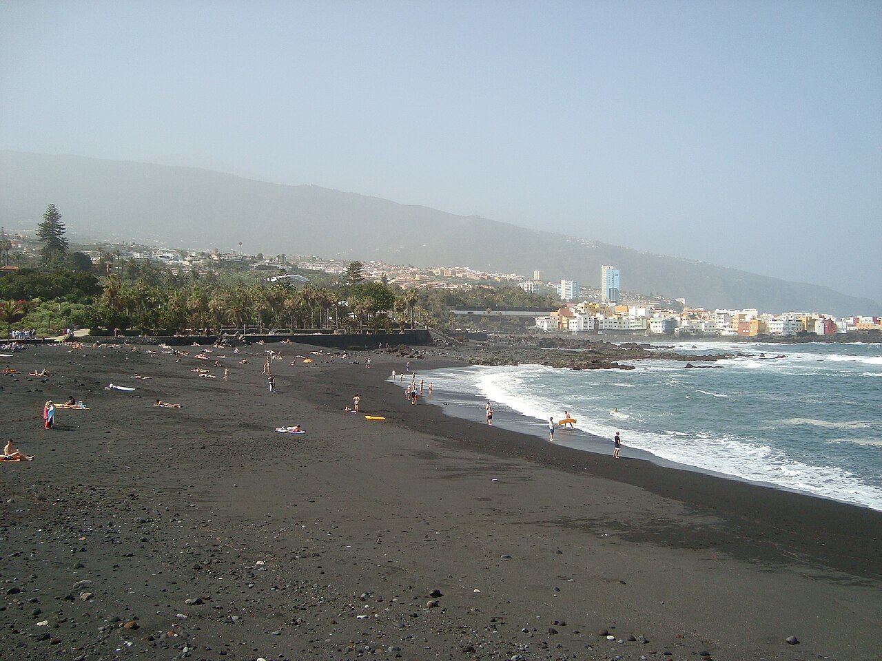 The black-sand beach of Playa Jardín with the coast behind
