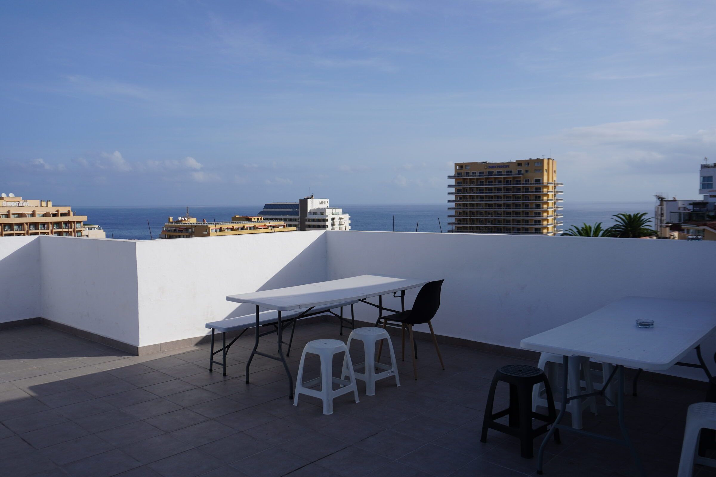 The rooftop terrace with tables and stools, the Atlantic and Puerto de la Cruz behind