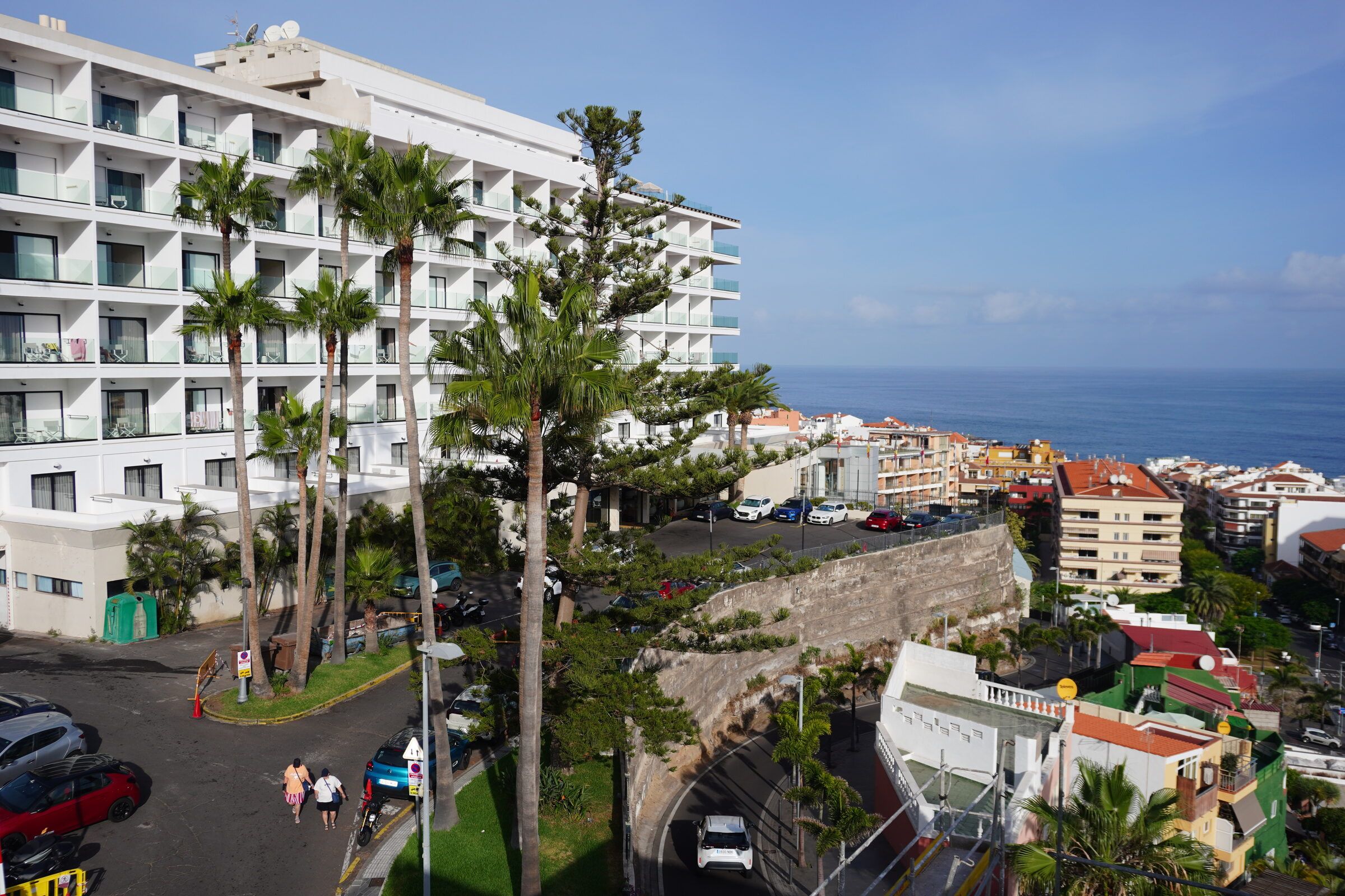 View from the rooftop down to the street, palm trees and the sea