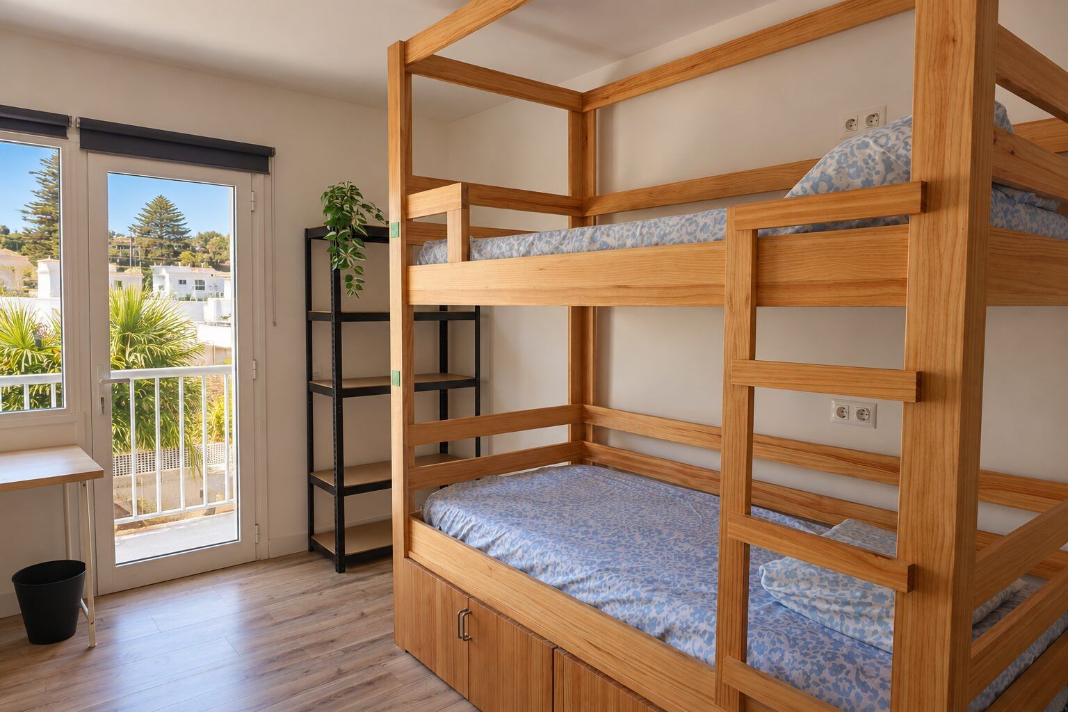 Room 5: wooden bunk bed next to a sunny balcony door with palm trees outside